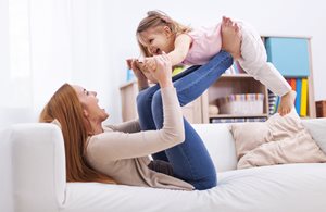 Mother playing airplane with child