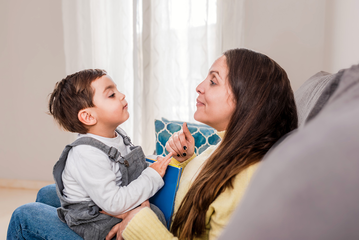 Parent and young child having a conversation on the couch