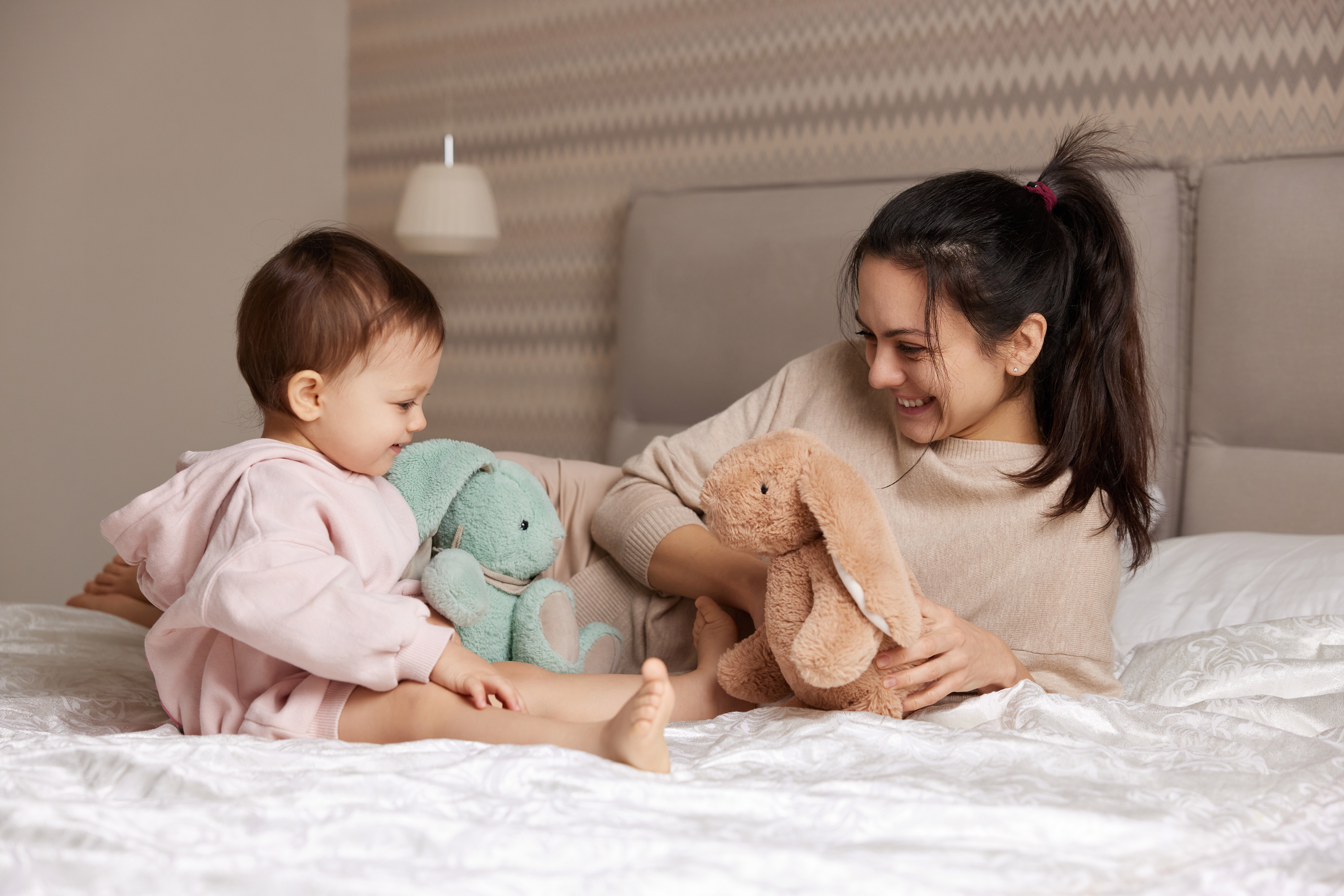 parent and young child playing with toy bunnies