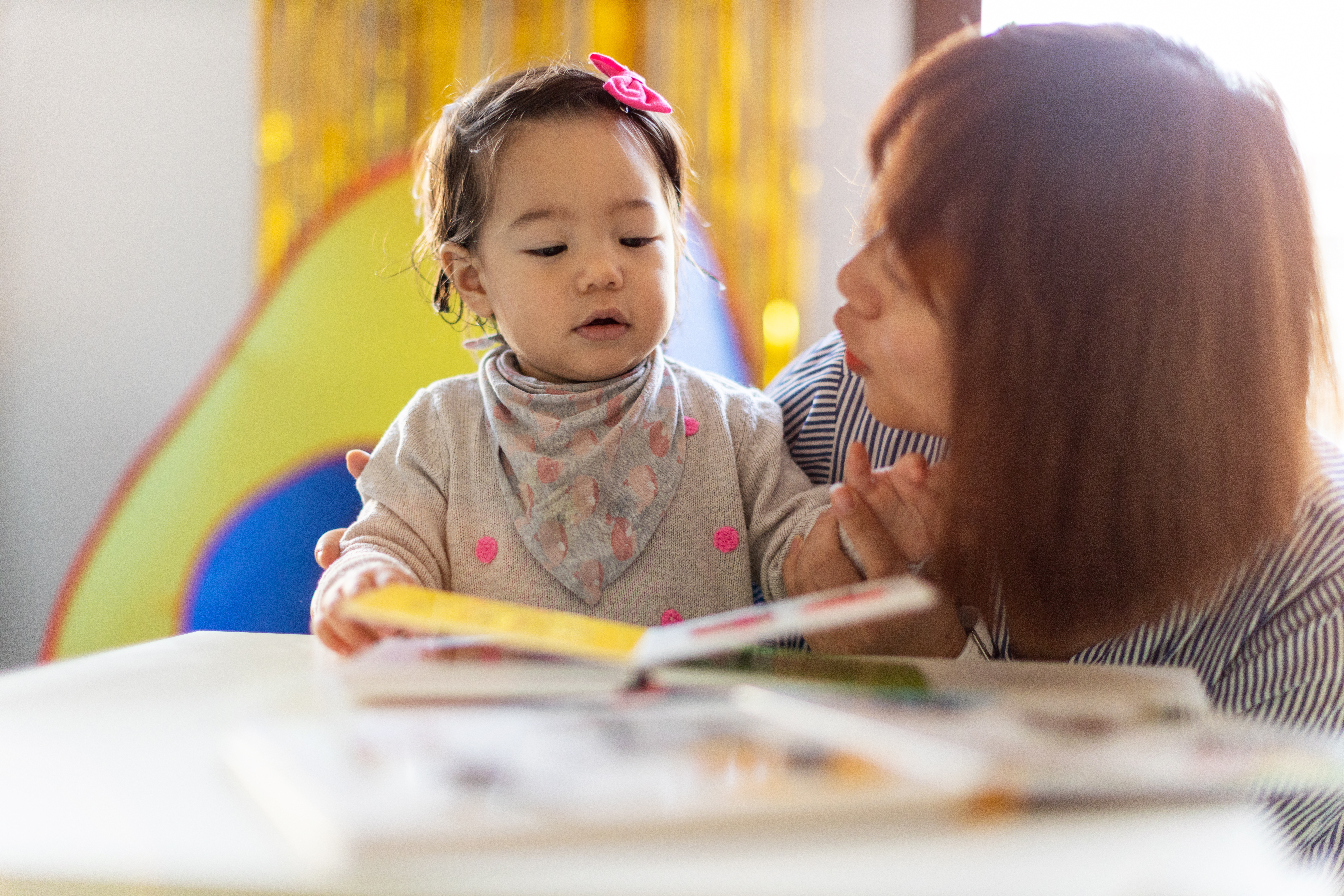 image of a very young child and a parent reading together
