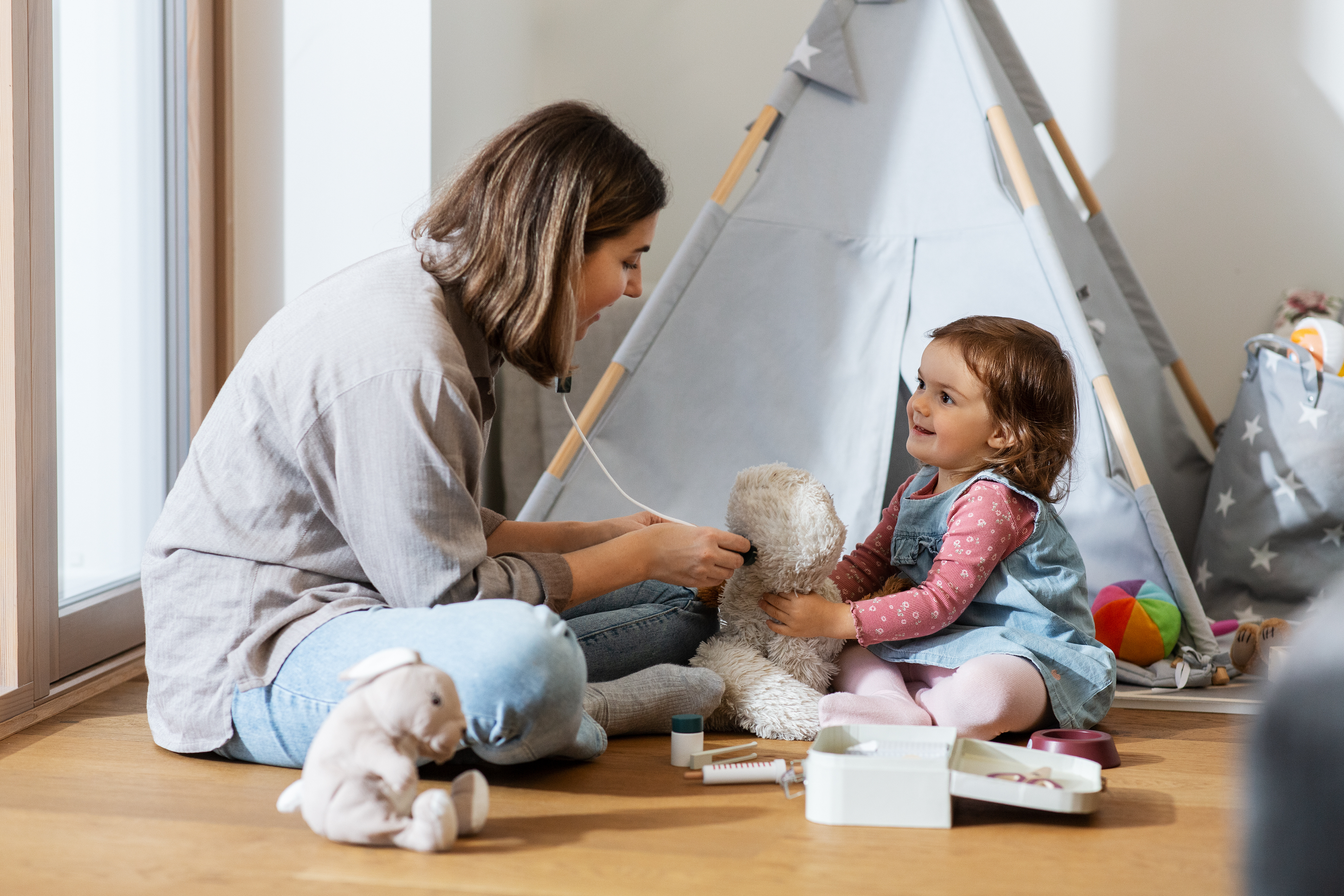 image of a parent and toddelr sitting on the floor playing together and talking happily